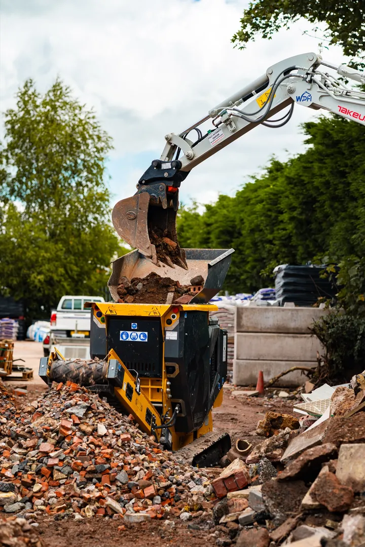 Excavator bucket over the CR450 hopper