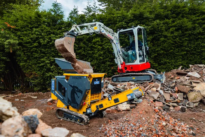 Mini excavator feeding the CR450 on a rubble heap